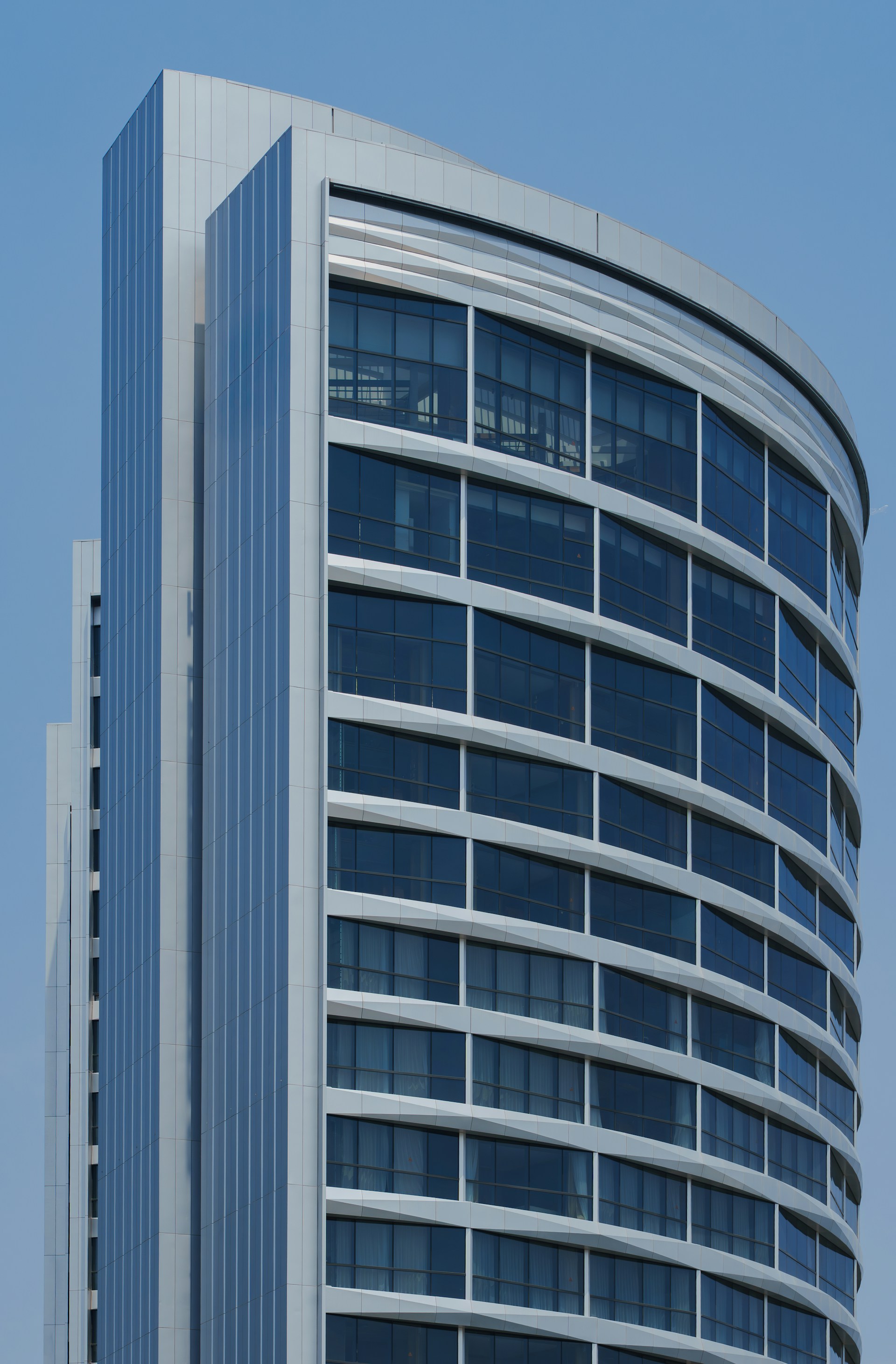 Glass architecture rising towards a clear blue sky